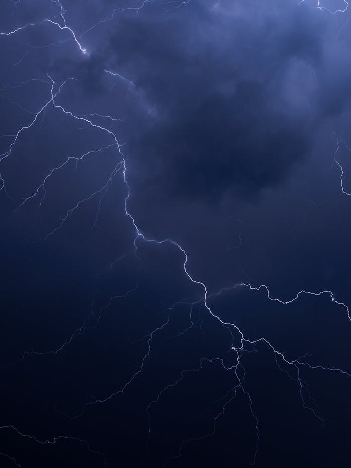 A striking image of a thunderstorm-lit night sky, showcasing vivid lightning bolts.